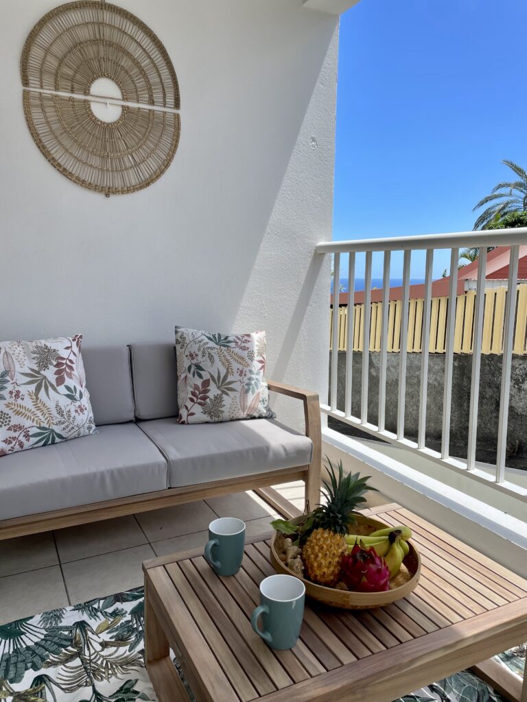 Photo du canapé et d'une corbeille de fruits sur la table basse sous la varangue